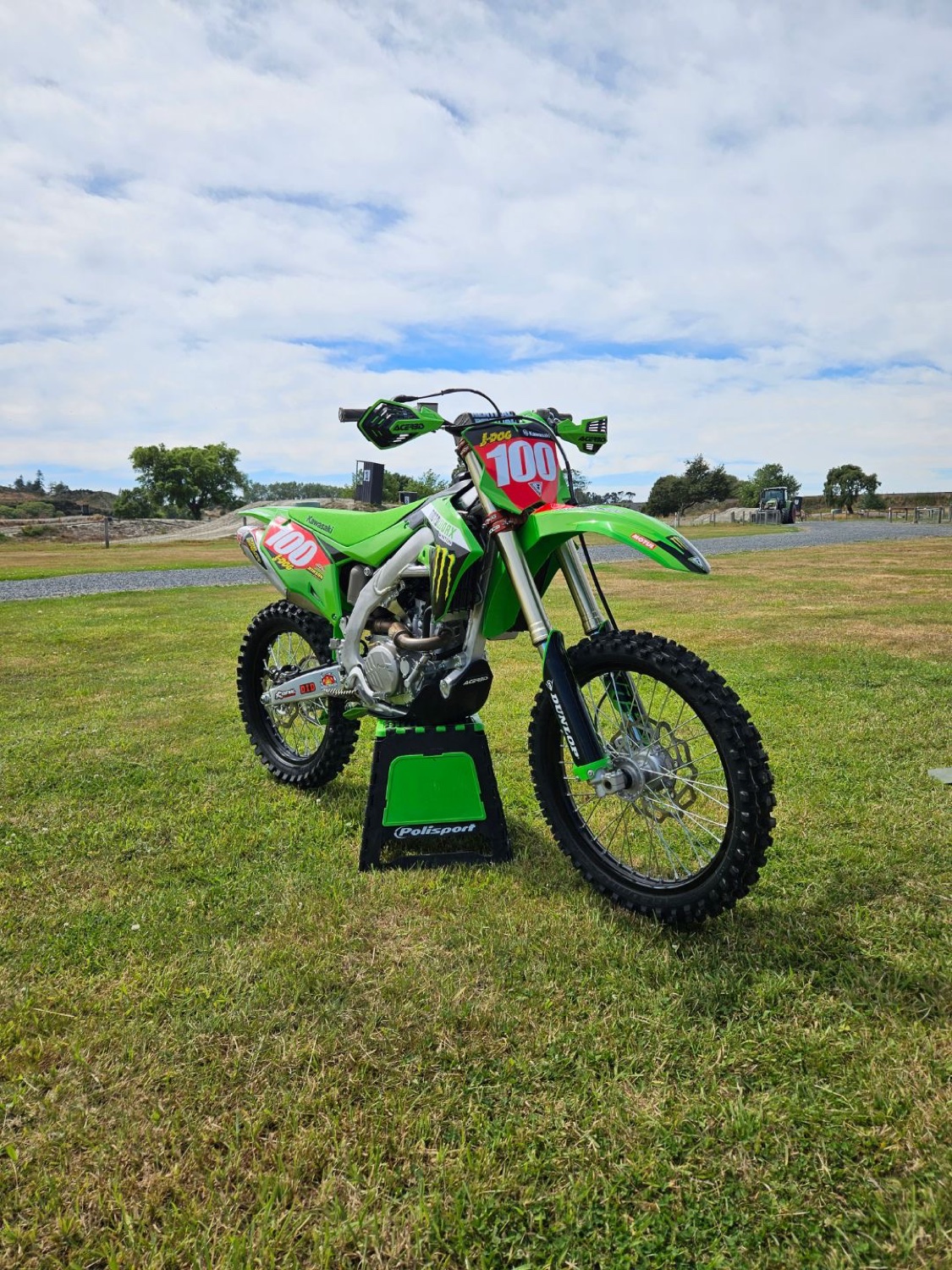 A green motorcycle outdoors on the grass